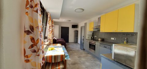 Wohnung Lena: Küche mit gelben Schränken und Essplatz
