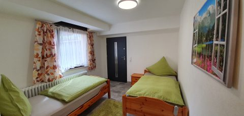 Wohnung Lena: Schlafzimmer mit zwei Einzelbetten und Tür zum Flur